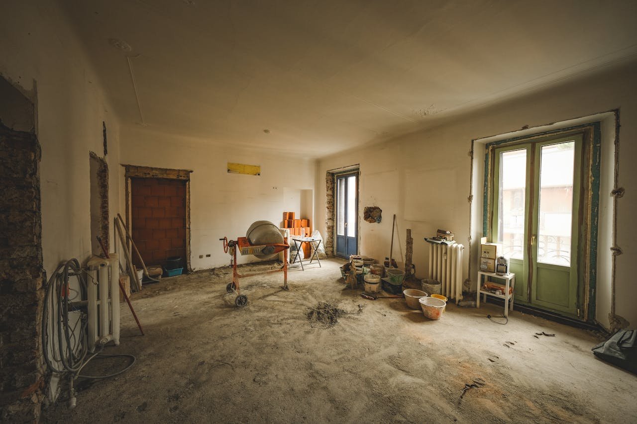 Wide view of a sunny room under renovation with construction materials and tools present, ideal for home improvement concepts.